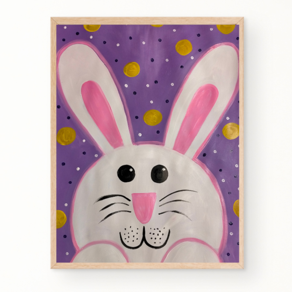 A framed painting of a white cartoon bunny with pink ears and cheeks against a purple background with gold and white polka dots.